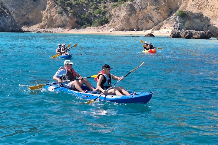 a group of people riding on the back of a boat in the water