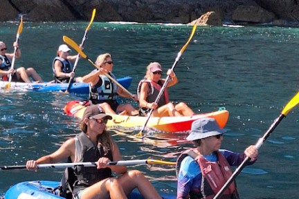 a group of people rowing a boat in the water