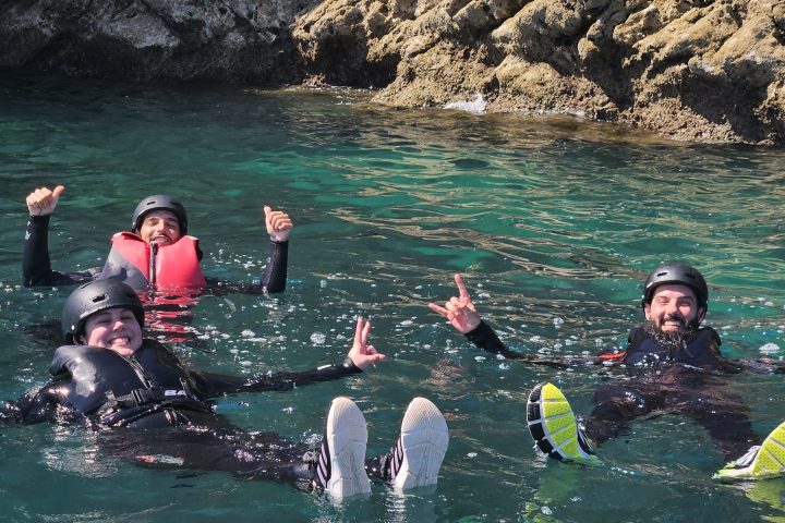 a group of people on a rock next to water