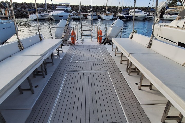View from boat deck towards a marina with moored yachts.