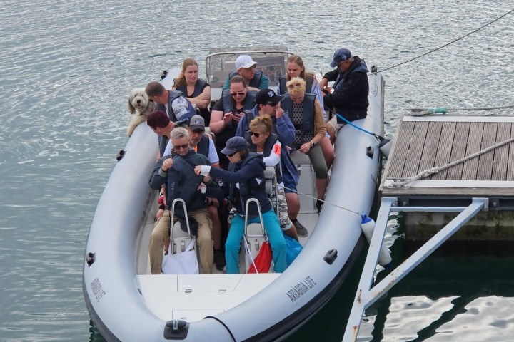 a group of people in a boat floating on a body of water