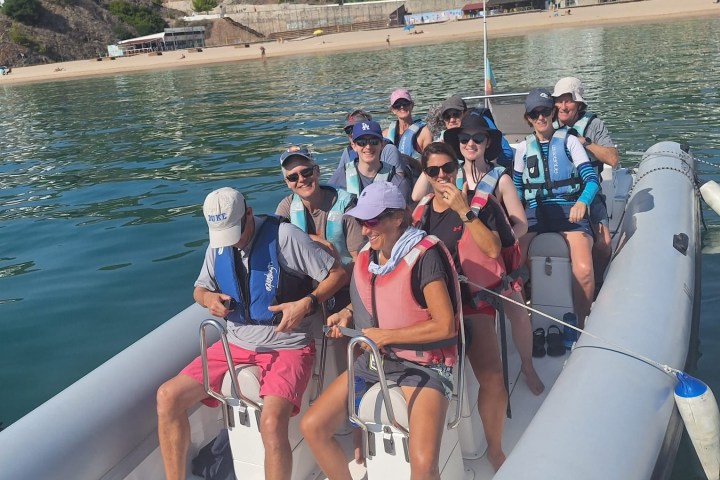 a group of people standing next to a body of water