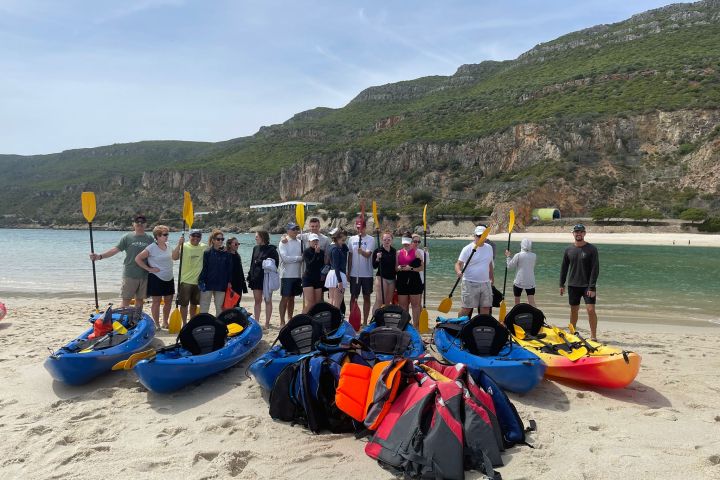 a group of people sitting at a beach