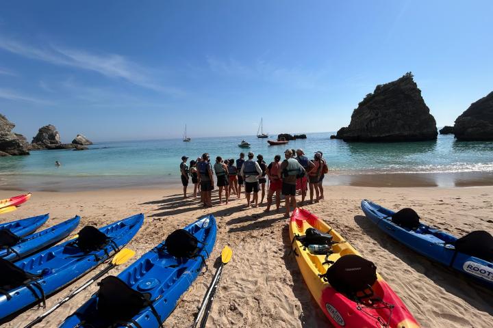 a group of people in a boat on the beach