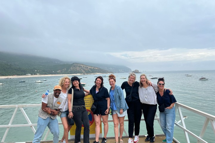 a group of people standing on a beach posing for the camera
