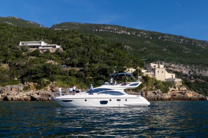 a small boat in a body of water with a mountain in the background