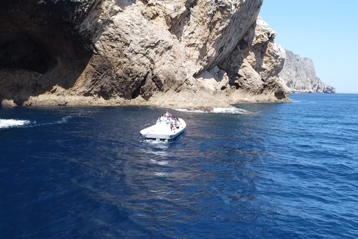 a small boat in a body of water with a mountain in the background