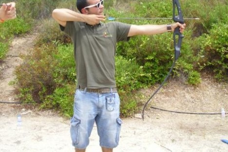 a man holding a kite while standing in the dirt
